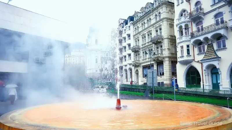 Hot spring geyser in karlovy vary, czech republic with steam rising
