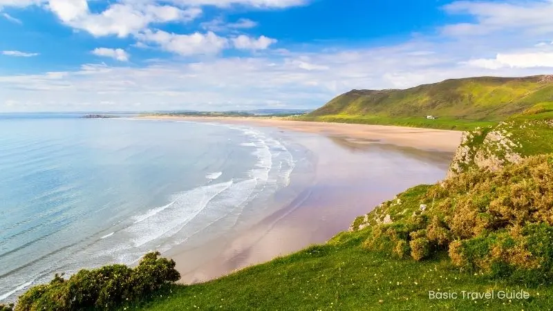 Rhossili bay, wales with golden sand and blue water