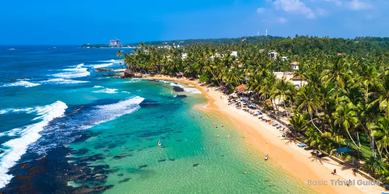Scenic view of unawatuna beach, sri lanka with palm trees and calm sea