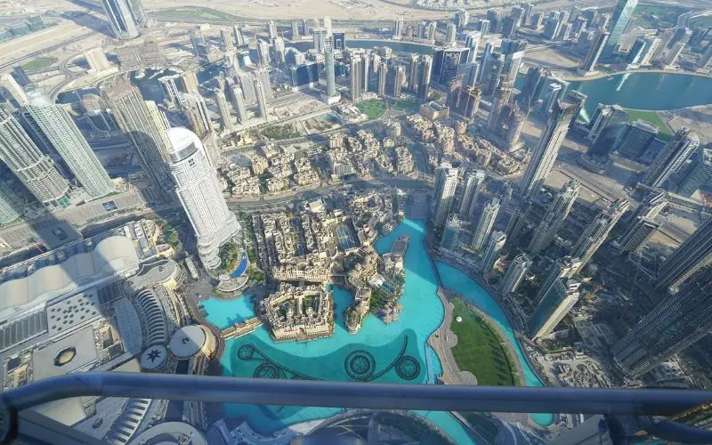 Sunset view from burj khalifa observation deck showing dubai skyline during golden hour transition