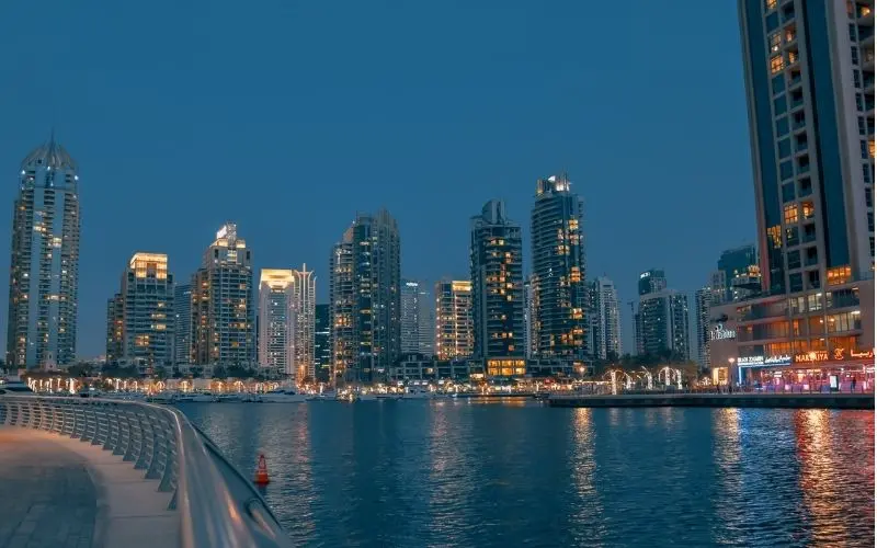 City lights reflection at dubai marina waterfront walkway