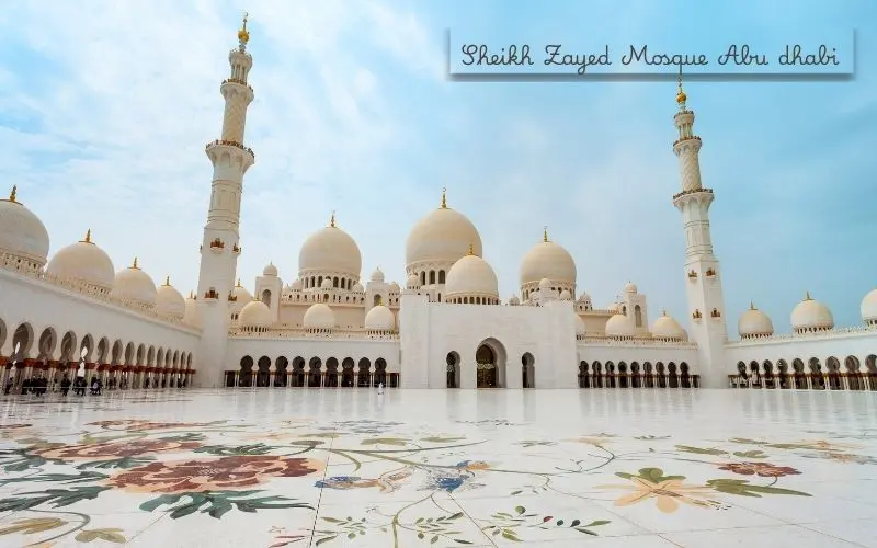 Sheikh zayed grand mosque in abu dhabi with white marble domes and reflective pools