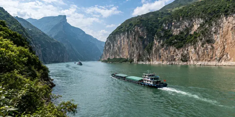 The yangtze river flowing through mountain gorges and lush landscapes in china